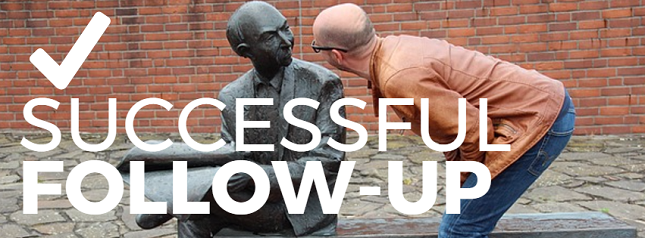 Successful follow-up. A man bending over to look face to face with statue of a man sitting down on a bench